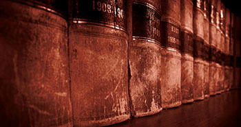 Image: Row of worn law books with dates listed on bottom of spine